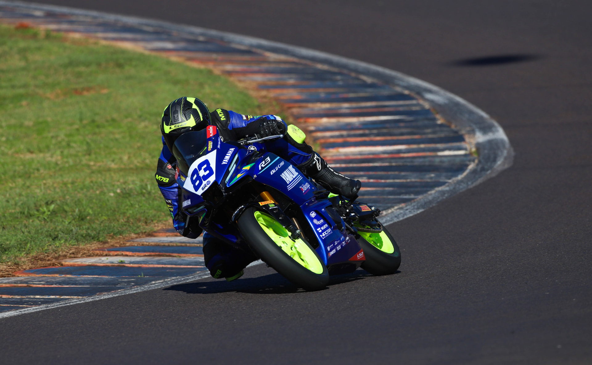 Yamaha R3 rider number 83 leaning through a fast corner