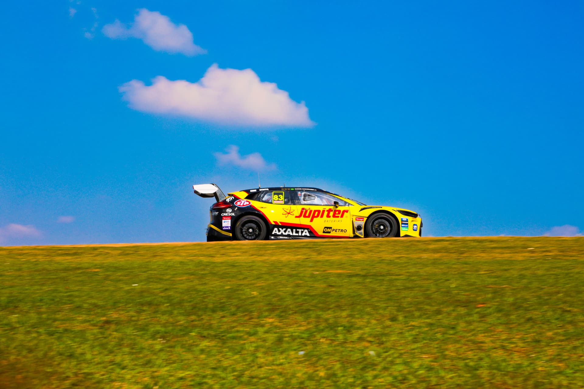 Jupiter Baterias stock car silhouetted on the crest of the track