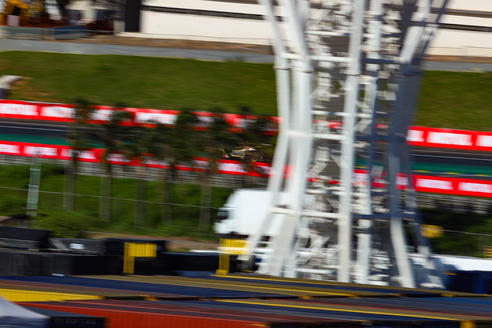 Hertz Team JOTA endurance prototype speeding past the grandstands at a WEC race