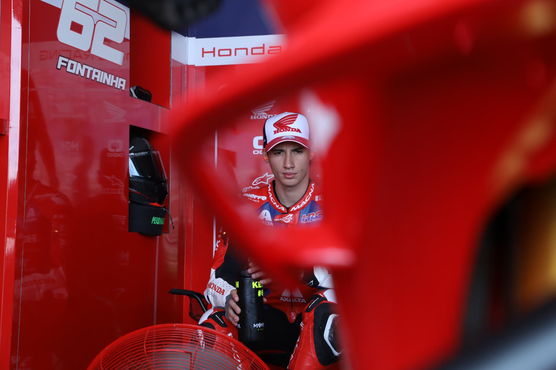 Honda Racing rider Fontainha framed through a red pit garage panel