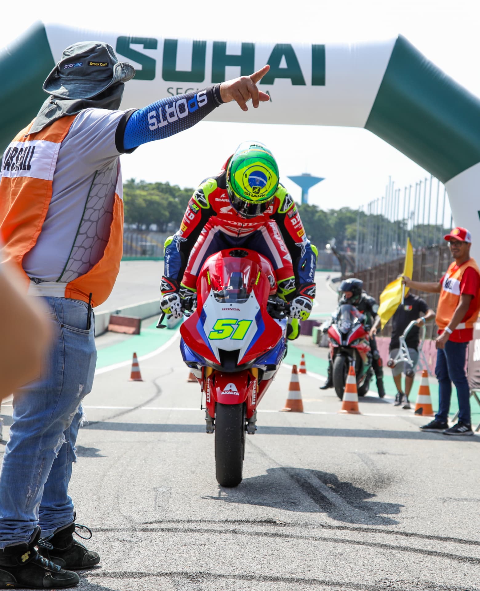 Rider pulling a wheelie past the start line arch