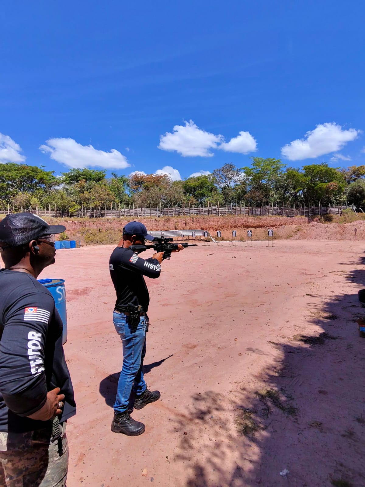 Instructor aiming a rifle downrange during tactical training
