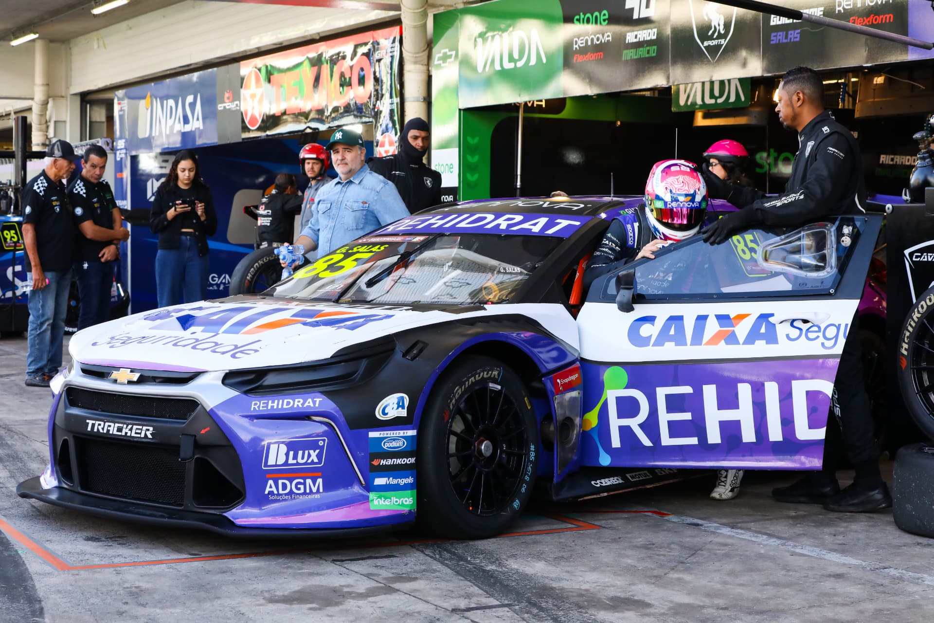 Driver climbing into the Rehidrat stock car in the pit garage
