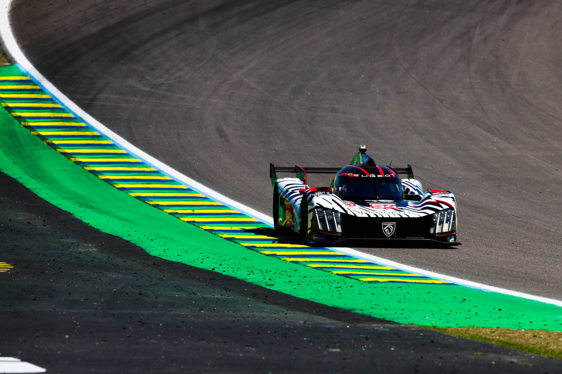 Peugeot 9X8 hypercar tracking the green and yellow kerbs at Interlagos