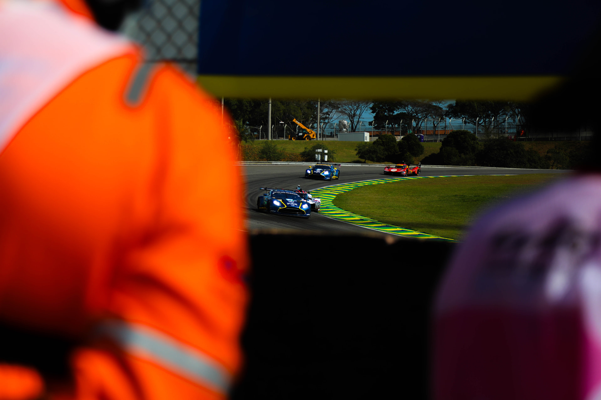 Aston Martin GT3 framed over a marshal's shoulder