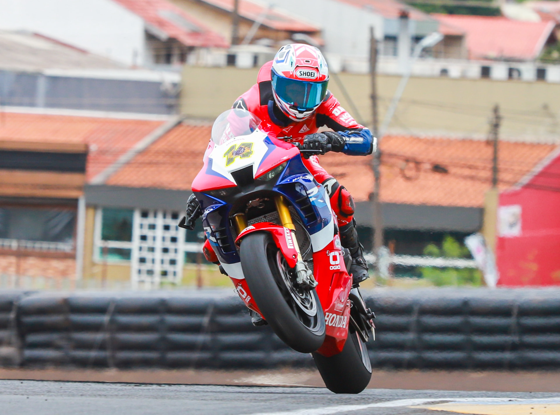 Honda rider lifting the front wheel out of a corner