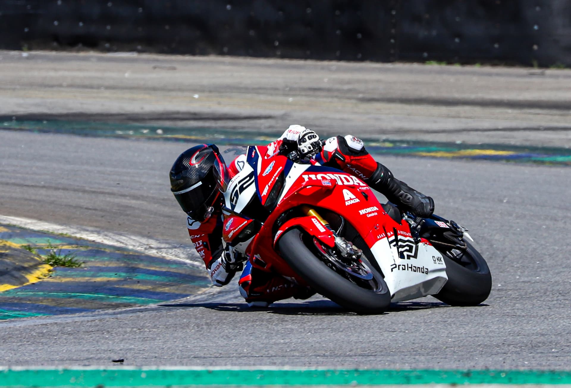Honda rider #52 leaning into the corner exit
