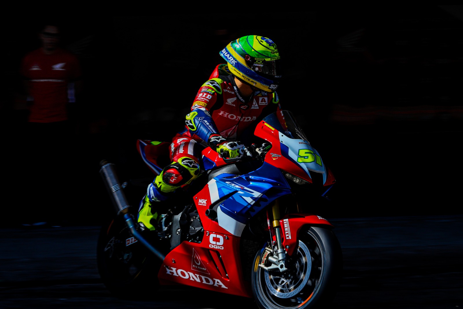 Honda superbike emerging from shadow in the pit lane