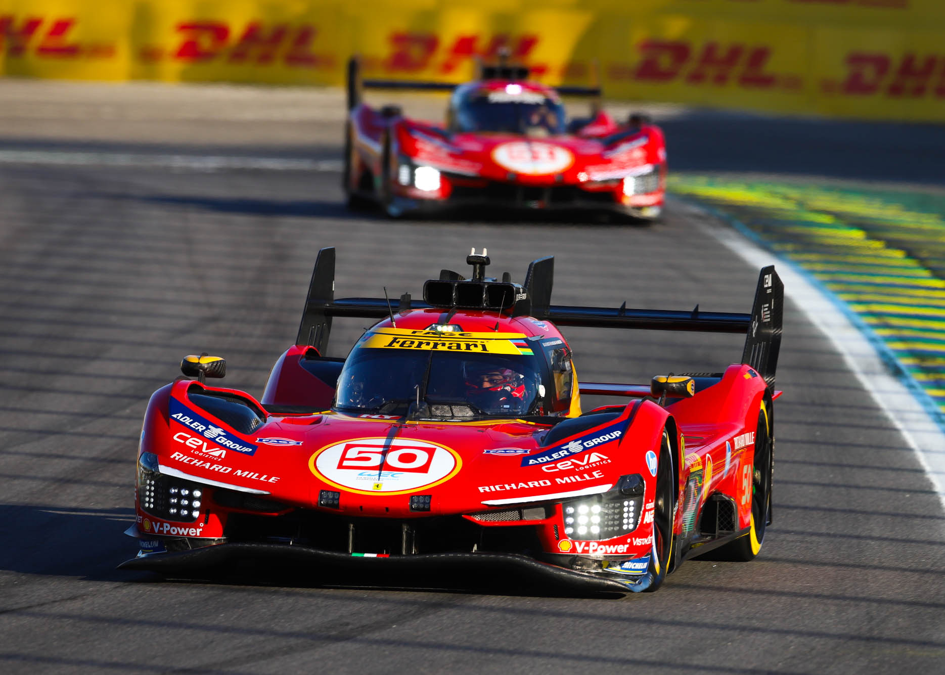 Ferrari 499P number 50 leading its sister car on the main straight